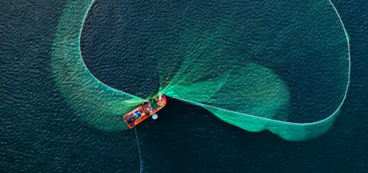 A fishing boat is opening a fish net to catch fishes on the sea of Phu Yen Vietnam